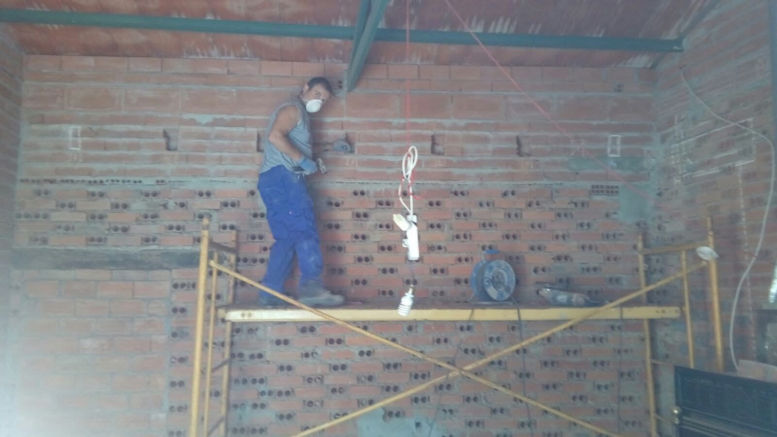 Juan Antonio trabajando en obra sobre un andamio