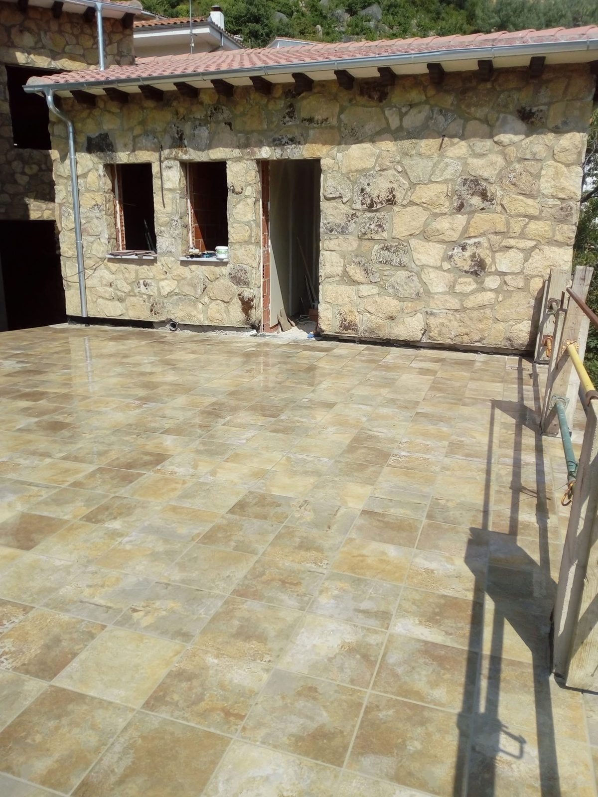 Terraza solada junto a una casa de piedra